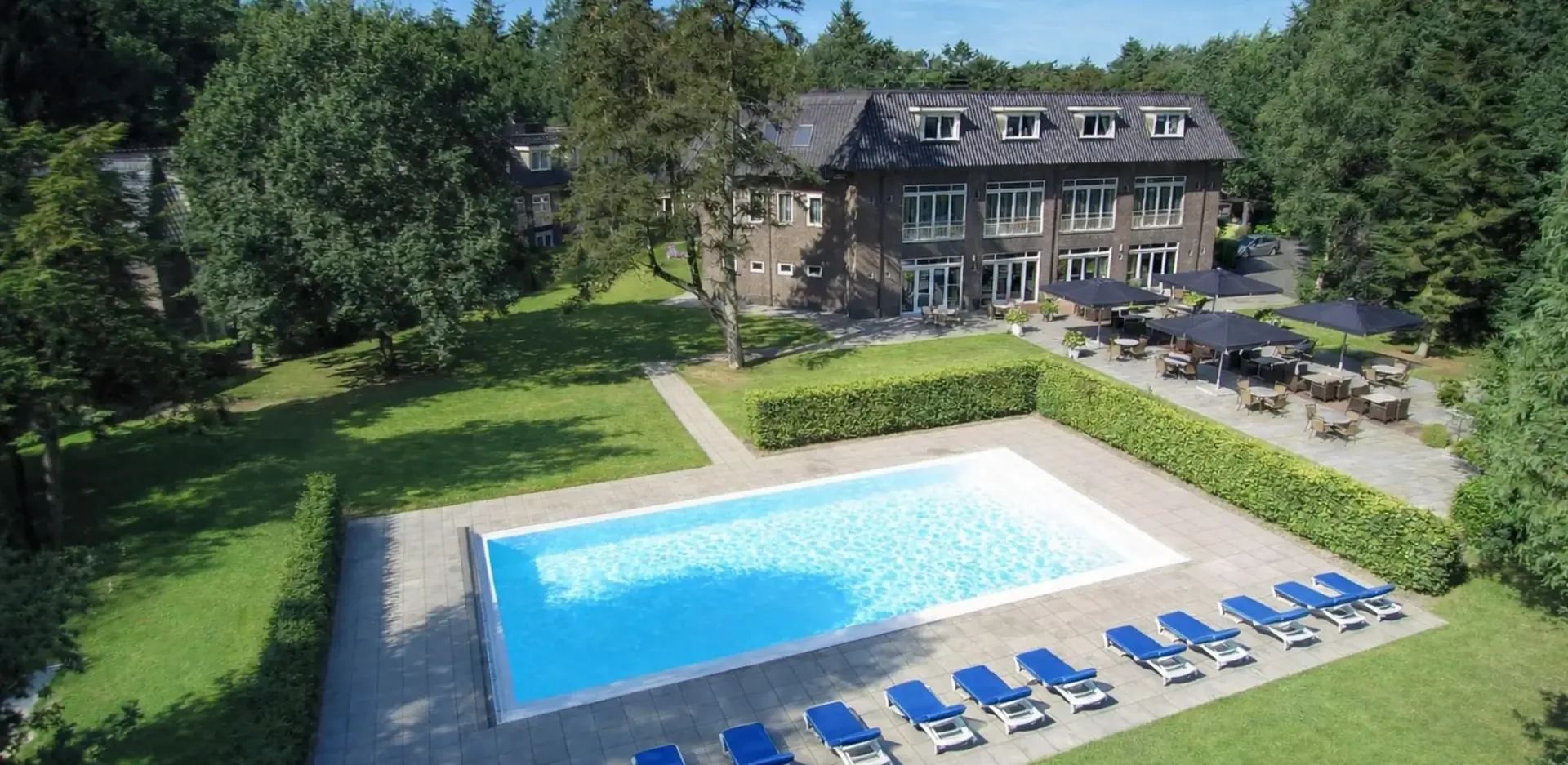 Buitenkant van Hotel de Werelt Garderen met zicht op zwembad