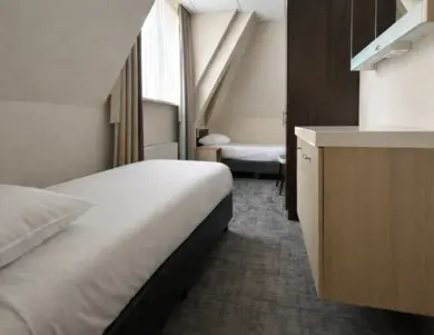 De eenpersoonsbedden op de familiekamer bij Hotel de Werelt Garderen