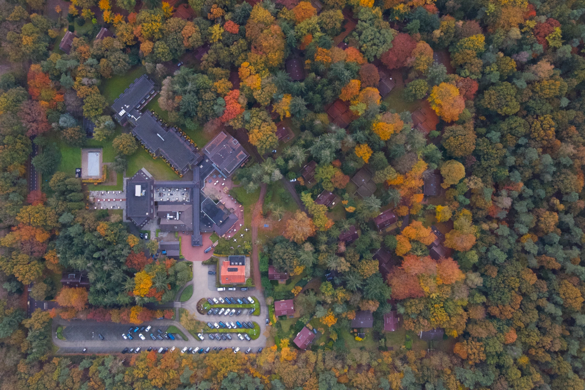Dronefoto van De Werelt Garderen, omringd door de bossen van de Veluwe, met hotel, vakantieverblijven en faciliteiten.